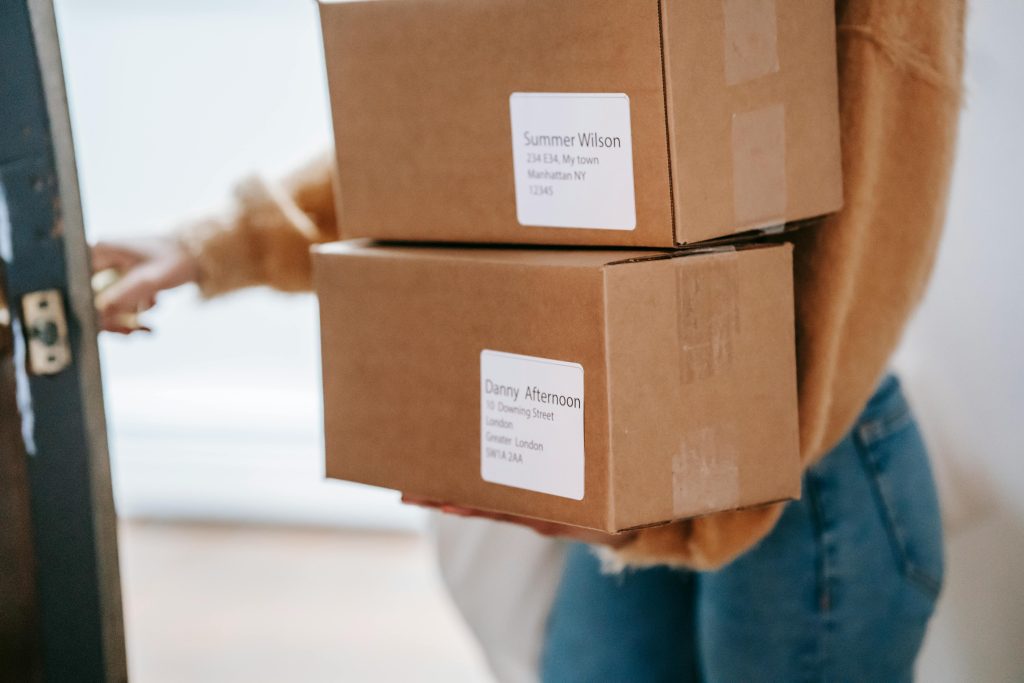 pexels-photo-6348105-6348105 Crop unrecognizable woman carrying boxes and entering post office